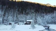 A picturesque winter scene in Montriond, France with snow-covered trees and a cabin.